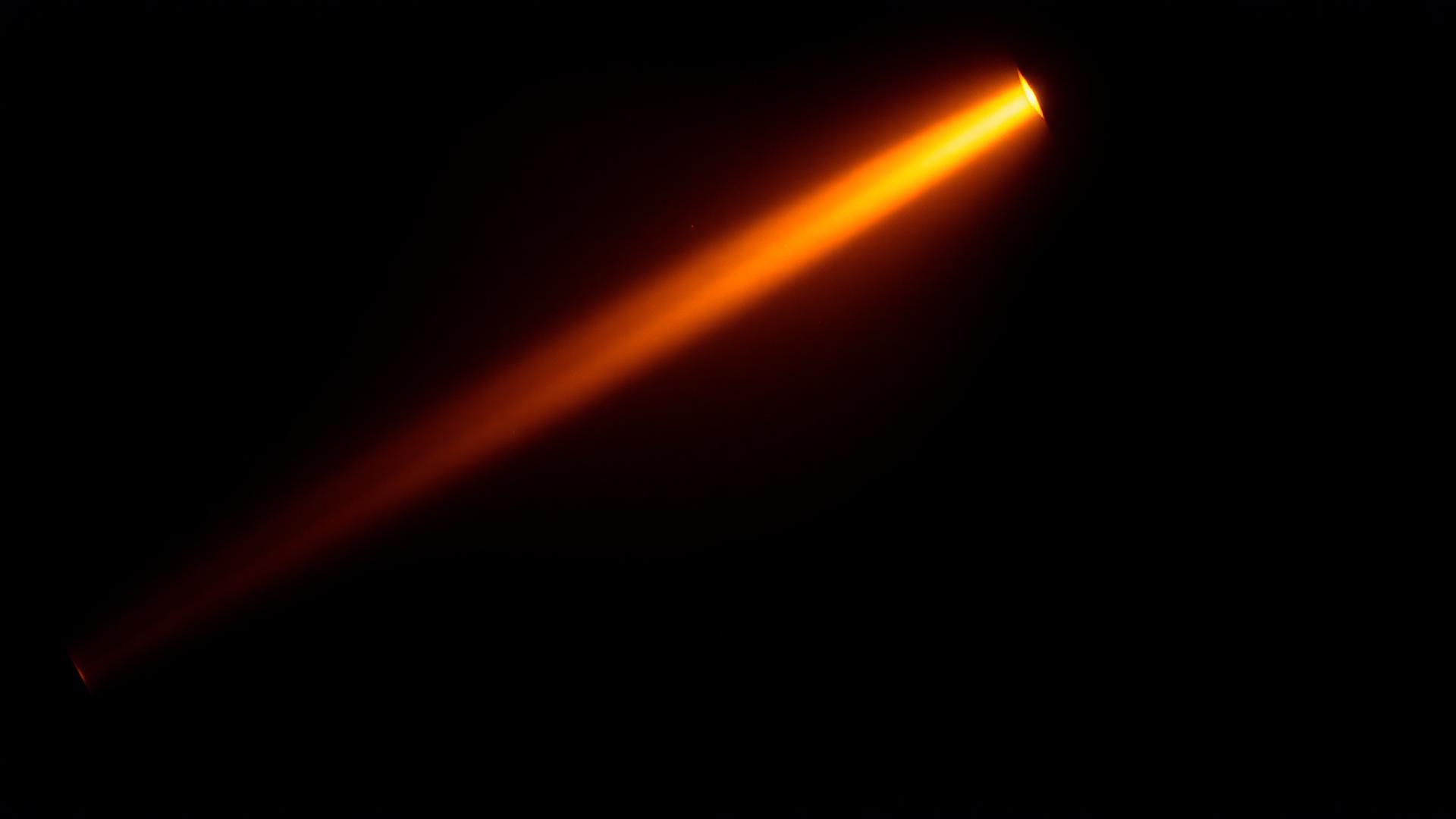 Warm projector beam cutting through a dim empty cinema hall